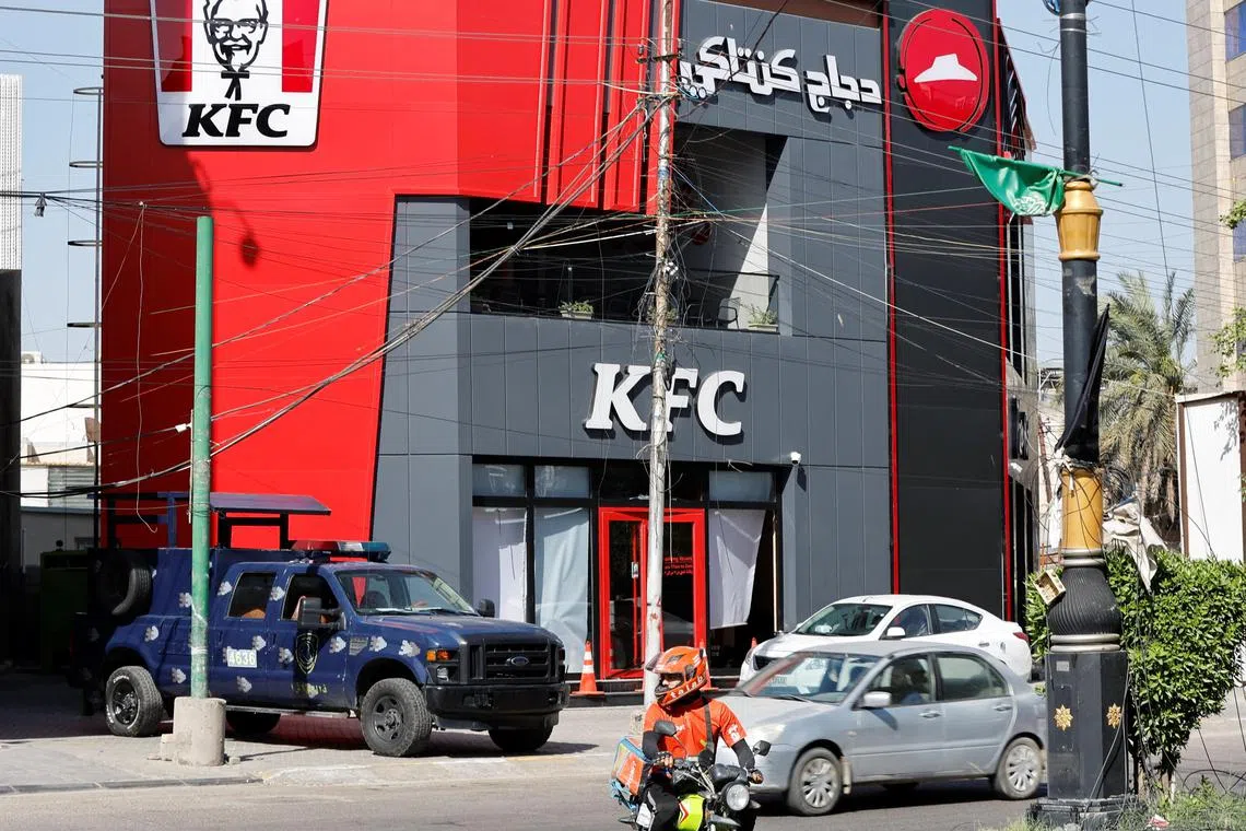 A police vehicle is parked near a KFC fast food restaurant following an attack in Baghdad on May 27. There have been three attacks on KFC outlets in the Iraqi capital in a week. 