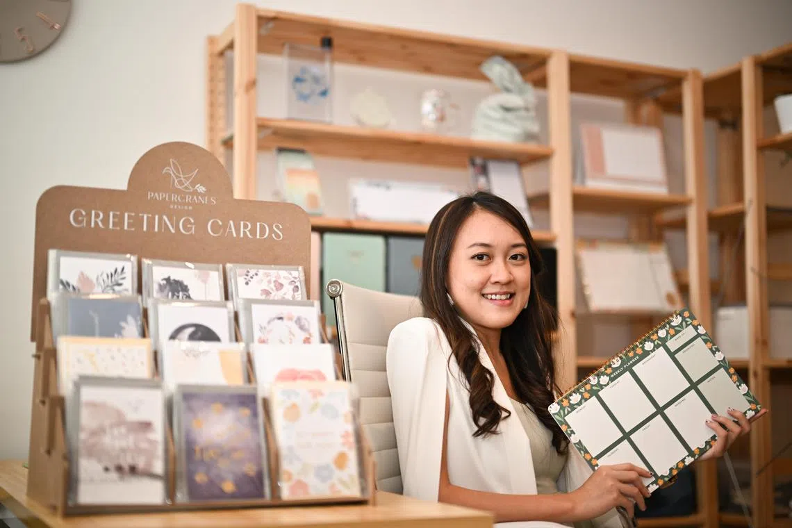 Ms Aerilynn Tan, 28, illustrator and founder of stationery and lifestyle brand Papercranes Design, with her products in her studio at Katong Plaza.