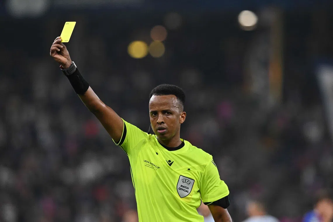 Somali referee Omar Artan shows a yellow card during the UEFA Supercup football match between Champions League winners Paris Saint Germain (PSG) and Europa League winners Aston Villa in Salzburg, Austria on August 12, 2026. (Photo by KERSTIN JOENSSON / AFP)