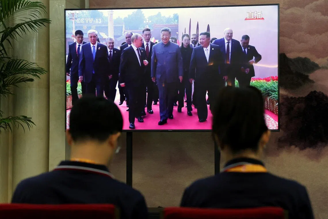 A TV screen shows Chinese President Xi Jinping, Russian President Vladimir Putin and North Korean leader Kim Jong Un arriving for a military parade marking the 80th anniversary of the end of World War Two, at a waiting room for media personnel in Beijing, China September 3, 2025. REUTERS/Florence Lo
