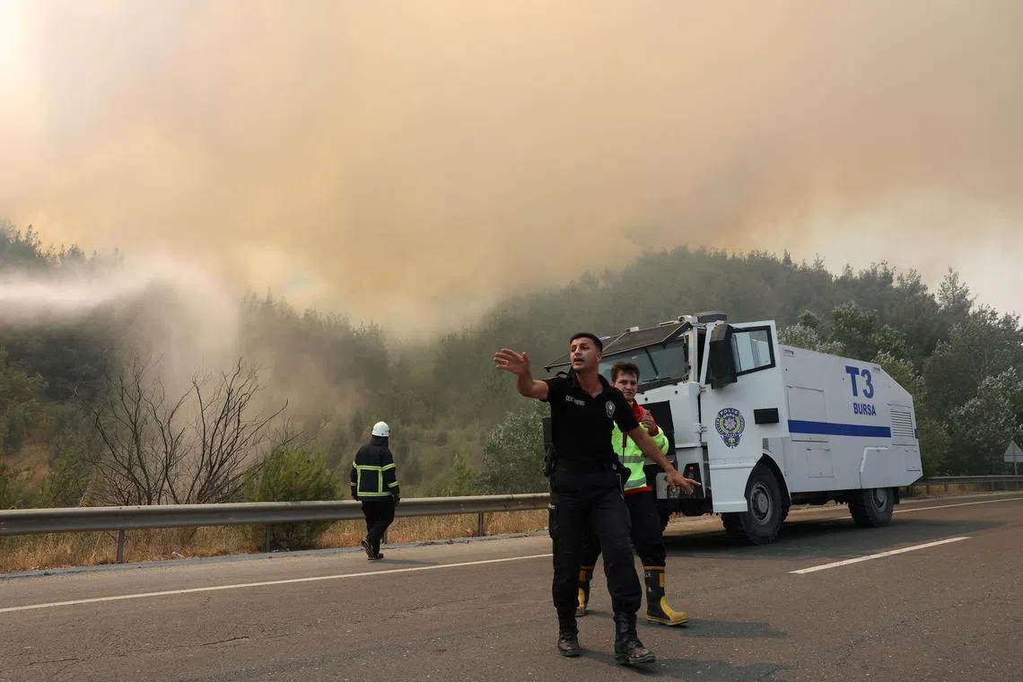 A police officer clearing the area ahead of the arrival of firefighters near Osmaneli, in Turkey's Bilecik province, on July 24.