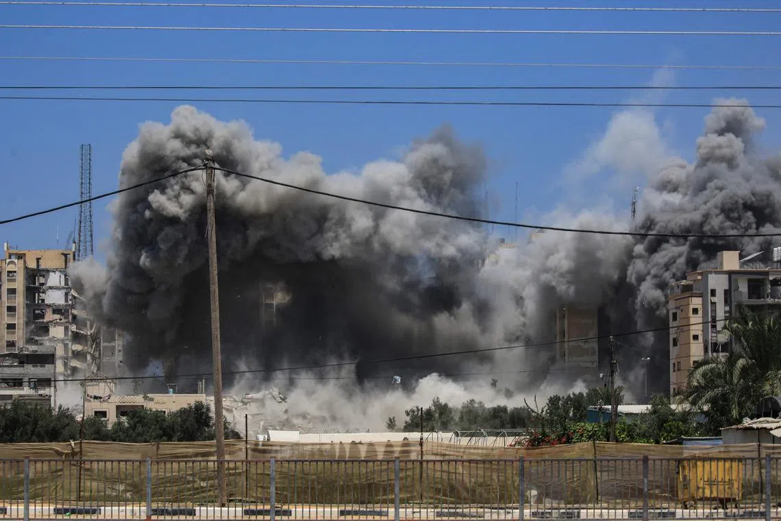 TOPSHOT - Smoke rises from a building hit by an Israeli strike in Nuseirat in the central Gaza Strip on July 20, 2024, amid the ongoing conflict between Israel and the Palestinian militant group Hamas. (Photo by Eyad BABA / AFP)
