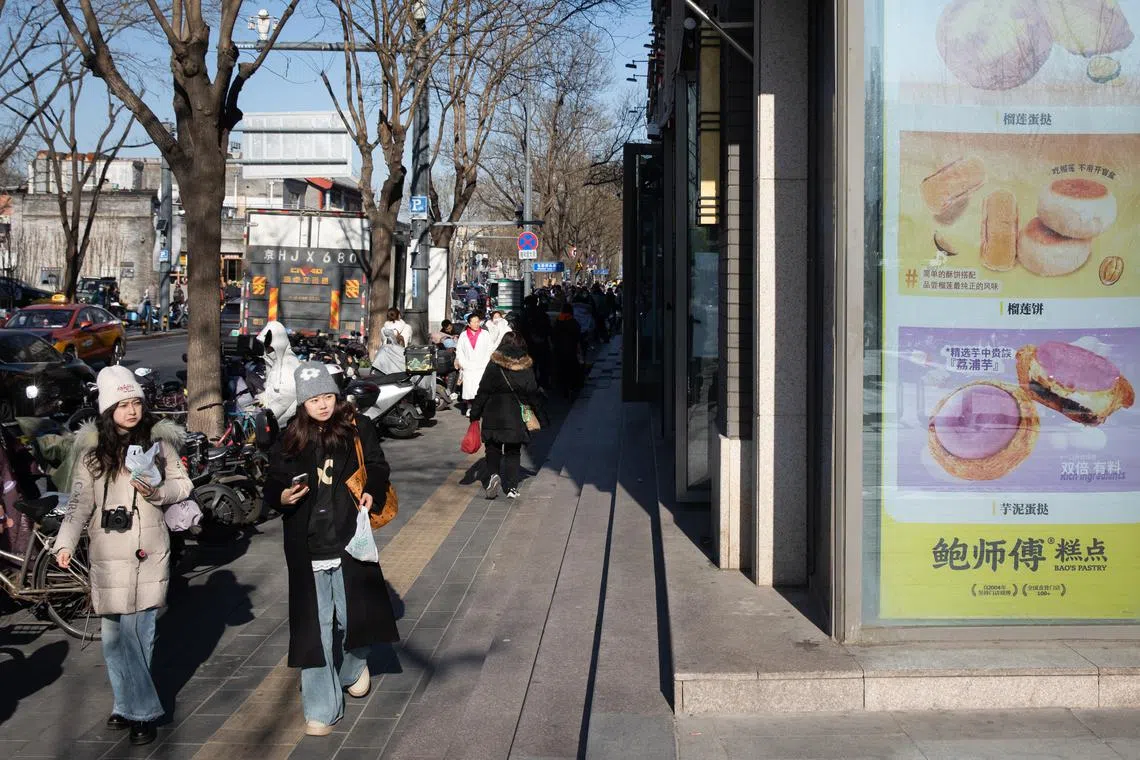 epa11765949 People walk near a shop selling food in Beijing, China, 09 December 2024. According to the National Bureau of Statistics, China's annual inflation rate unexpectedly dropped to 0.2 percent in November 2024 from the previous month’s 0.3 percent. The Consumer Price Index decreased 0.60 percent in November 2024 from the previous month. EPA-EFE/JESSICA LEE
