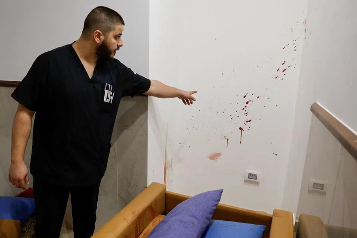 A man points at blood stains at the site where three Palestinians were killed during an Israeli raid, at a hospital in Jenin, in the Israeli-occupied West Bank, January 30, 2024. REUTERS/Raneen Sawafta/File Photo