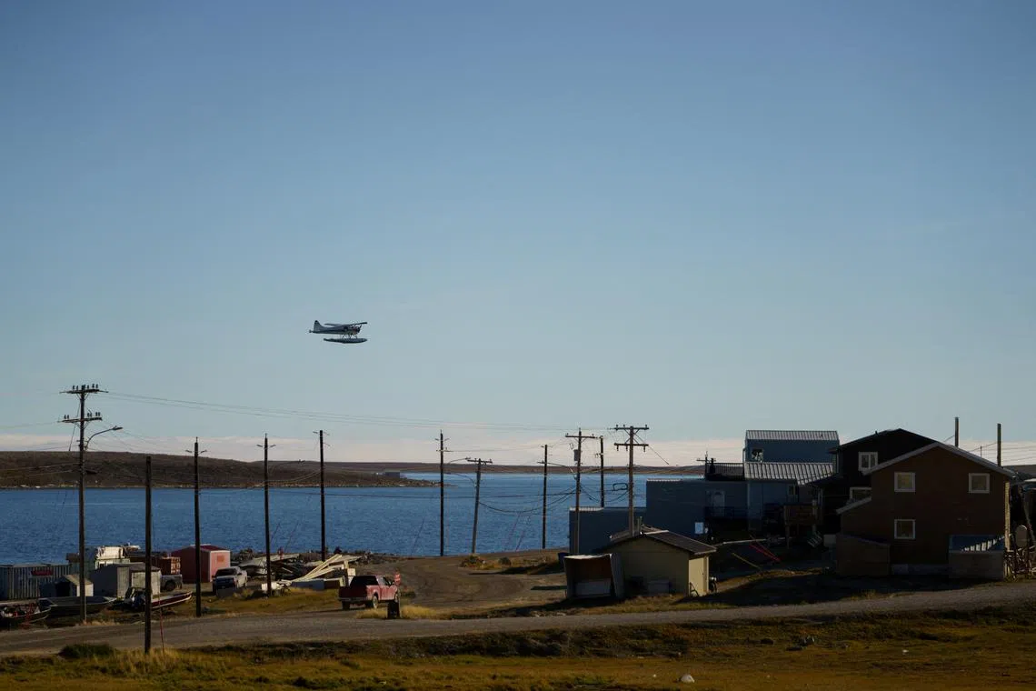 FILE PHOTO: A float plane flies past the Arctic community of Cambridge Bay, Nunavut, Canada August 25, 2022.  Adam Scotti/Prime Minister's Office/Handout via REUTERS/File Photo