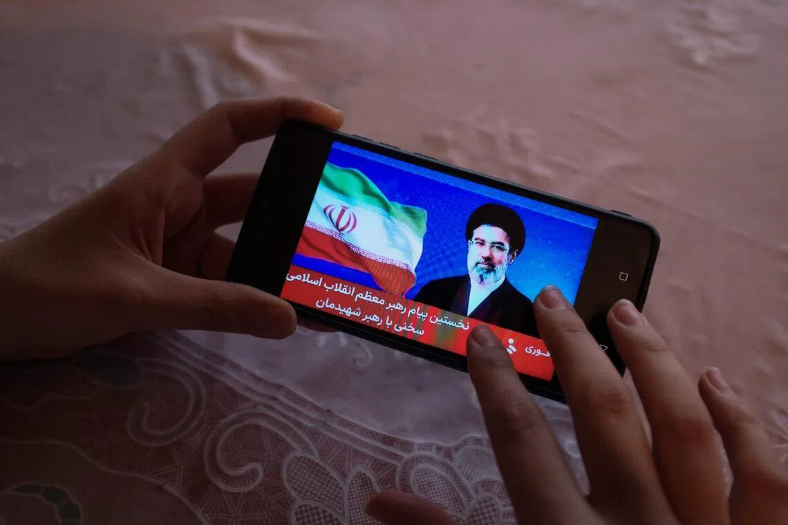 A girl watches a televised statement by Iran's new supreme leader Mojtaba Khamenei on a mobile phone on March 12.