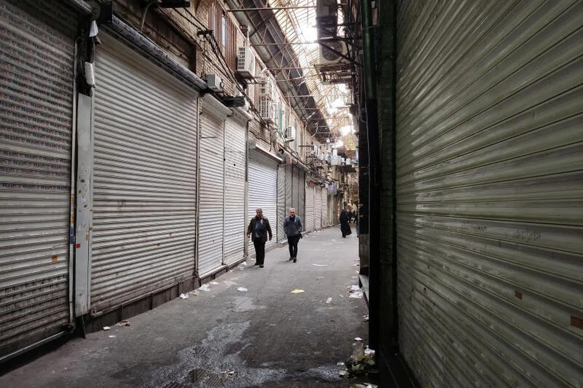 People passing shuttered shops after a call from Iranian protesters to close markets, in Teheran Bazaar, in Teheran, Iran, on Nov 16, 2022. 