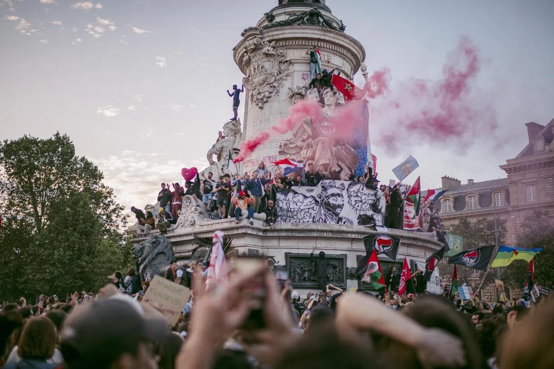 People celebrate after the second round of the French legislative elections at Place de la Republic in Paris on July 7. The far-right National Rally appeared to have fallen short of predictions, but no coalition captured an absolute majority in parliament, according to projections.