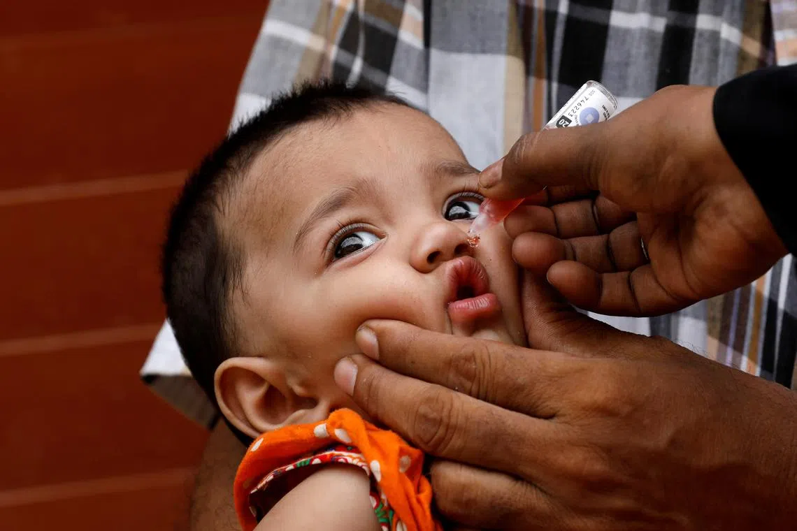 FILE PHOTO: A girl receives polio vaccine drops, during an anti-polio campaign, in a low-income neighborhood in Karachi, Pakistan July 20, 2020. REUTERS/Akhtar Soomro/File Photo