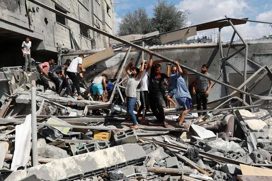 Palestinians search for casualties at the site of Israeli strikes on houses in Rafah in the southern Gaza Strip October 17, 2023. REUTERS/Ibraheem Abu Mustafa
