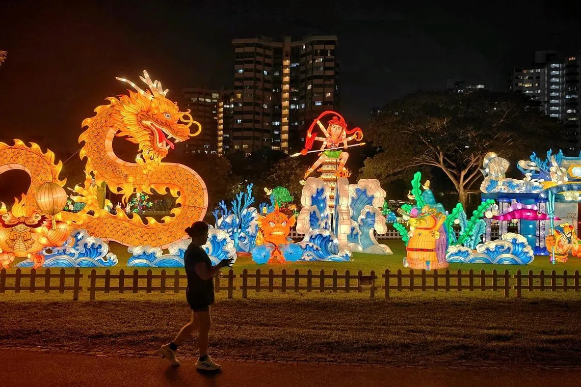 A park goer walking past a lantern titled Nezha And The Dragon King during a media preview of Lights by the Lake, a gala of lights, music and cultural delights, at Jurong Lake Gardens on Sept 5, 2024. In its third and largest edition, the annual Lights by the Lake, which is organised by National Parks Board, will run from Sept 8 to 22 in celebration of Mid-Autumn Festival. More than 300 handcrafted lanterns depicting Chinese mythology, the Gardens' biodiversity and familiar landmarks will be lit up nightly at Jurong Lake Gardens. ST PHOTO: KEVIN LIM