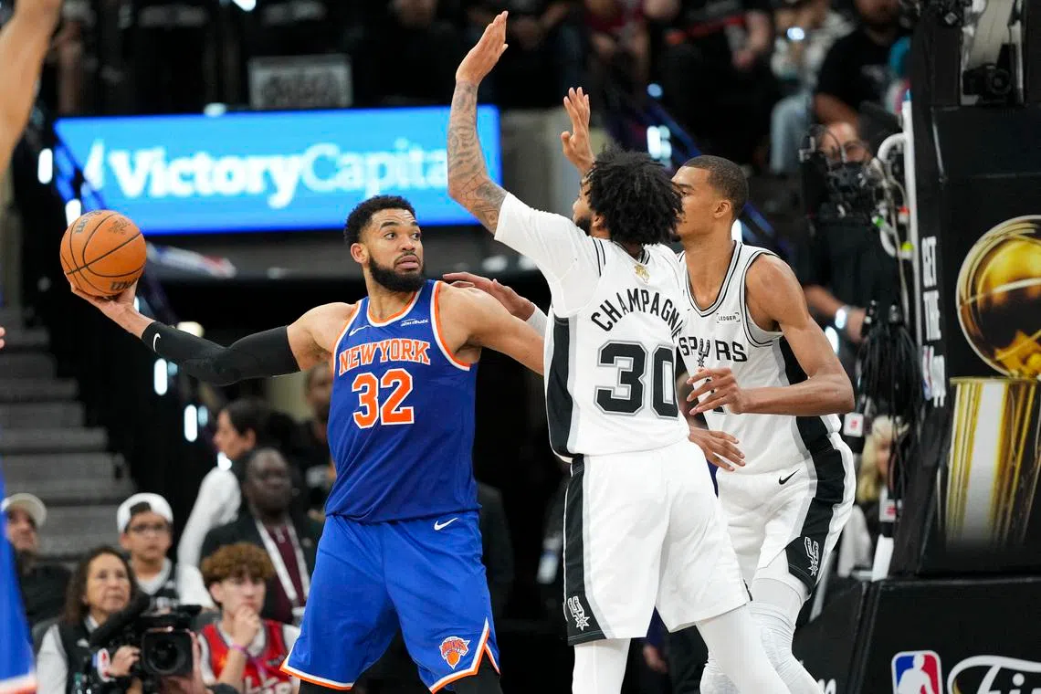 Jun 5, 2026; San Antonio, Texas, USA; New York Knicks center Karl-Anthony Towns (32) looks to passes the ball past San Antonio Spurs forward Julian Champagnie (30) and forward Victor Wembanyama (1) in the second half during game two of the 2026 NBA Finals at Frost Bank Center. Mandatory Credit: Scott Wachter-Imagn Images