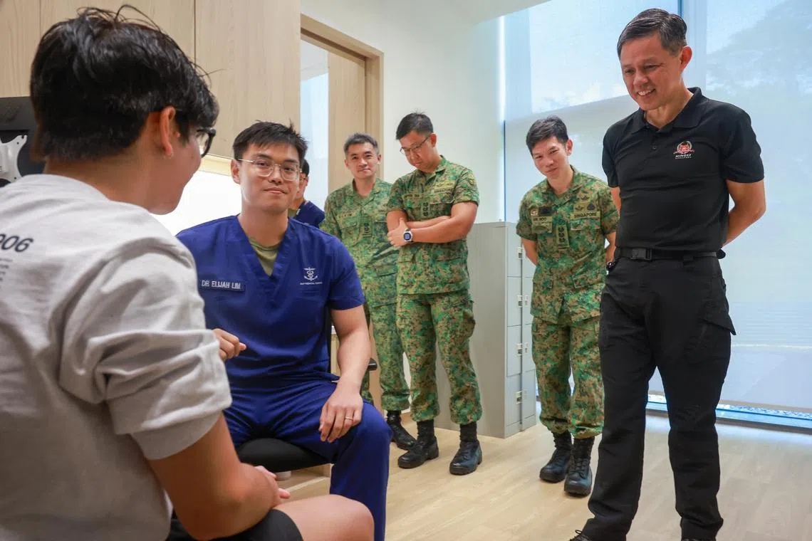 Minister for Defence Chan Chun Sing (right) meeting a pre-enlistee undergoing a medical examination at the regional health hub on April 13.
