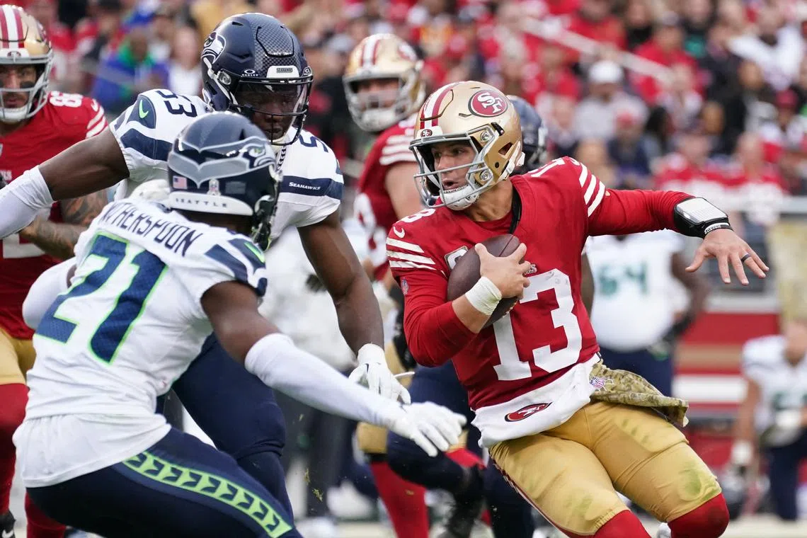 FILE PHOTO: Nov 17, 2024; Santa Clara, California, USA; San Francisco 49ers quarterback Brock Purdy (13) scrambles away from Seattle Seahawks cornerback Devon Witherspoon (21) in the third quarter at Levi's Stadium. Mandatory Credit: David Gonzales-Imagn Images/File Photo