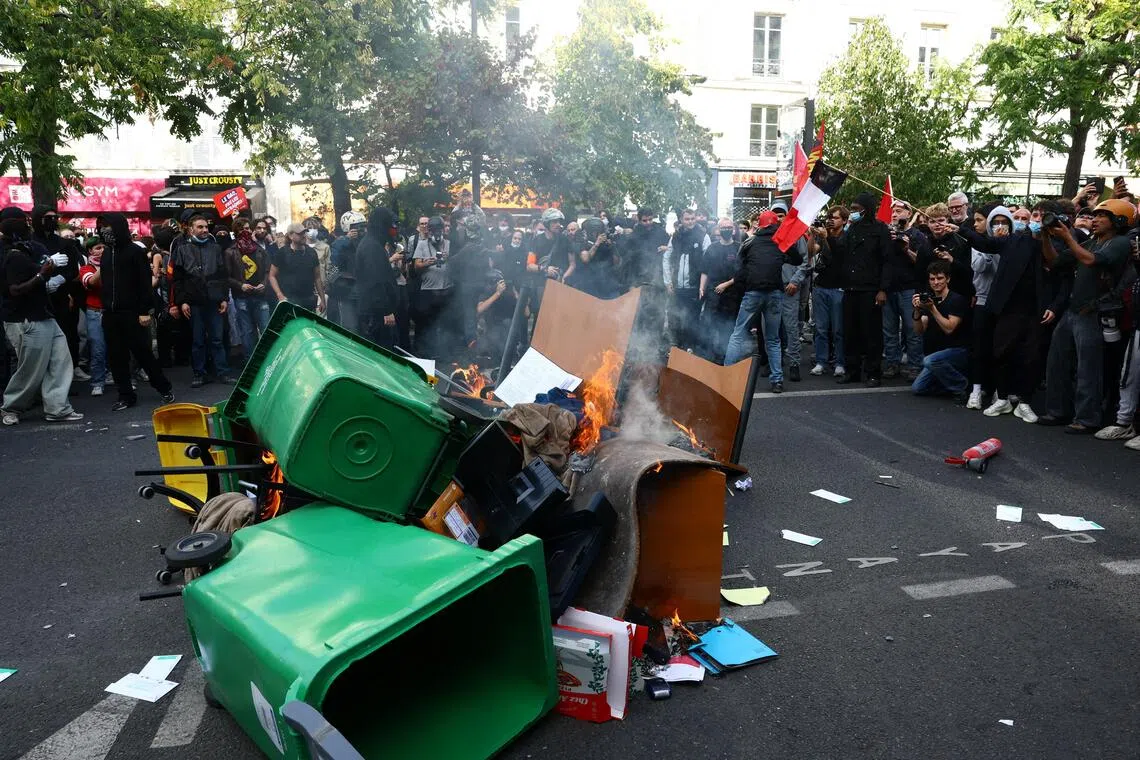 Garbage bins and other objects are set on fire by protesters amid clashes with French police.