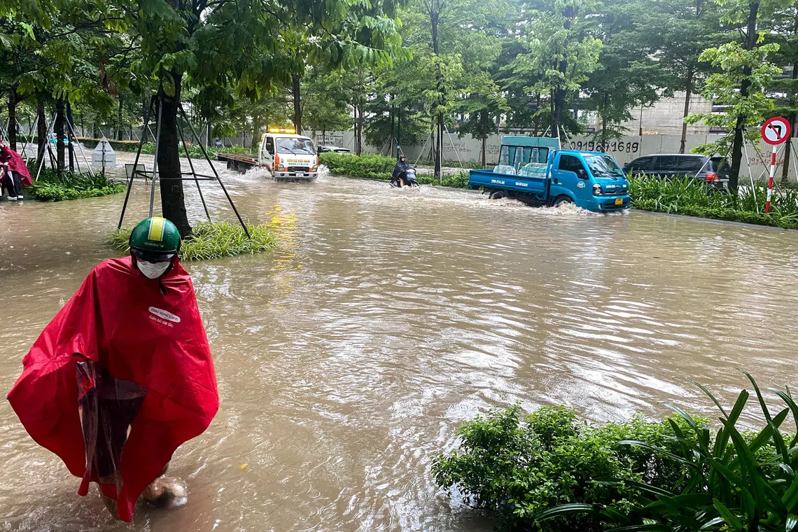People commute on a flooded street after Typhoon Bualoi made landfall in Hanoi, Vietnam, September 30, 2025. REUTERS/Frencesco Guarascio