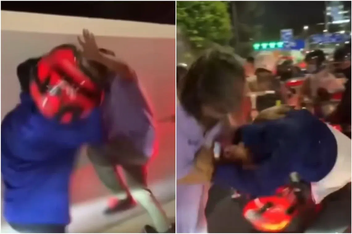 In the video, two men are seen exchanging blows with their helmets near the motorcycle lanes.