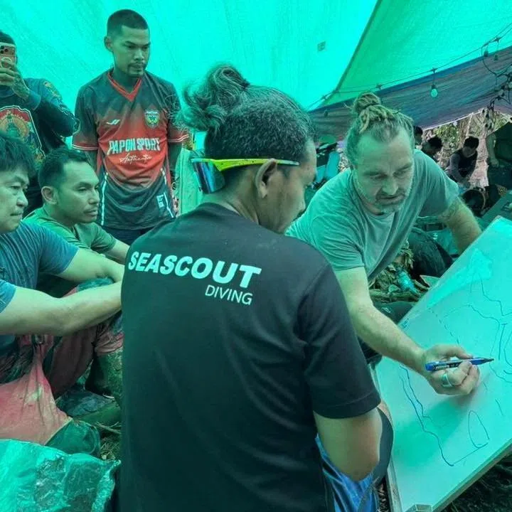 Rescue workers gather to discuss plans to rescue people trapped in a cave, in Xaisomboun Province, Laos, in this handout image released on May 29.