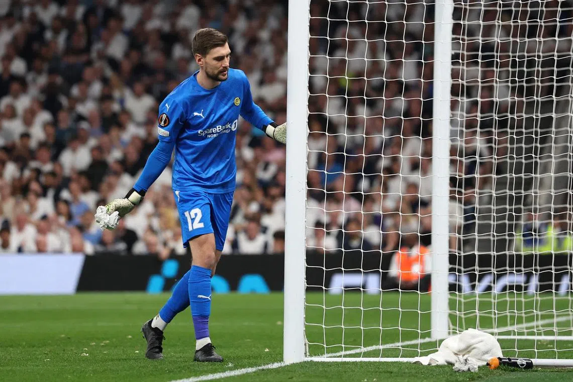 Soccer Football - Europa League - Semi Final - First Leg - Tottenham Hotspur v Bodo/Glimt - Tottenham Hotspur Stadium, London, Britain - May 1, 2025 Bodo/Glimt's Nikita Haikin with an object in his hands that had been thrown onto the pitch by fans REUTERS/David Klein