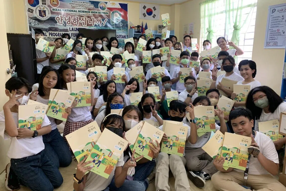 Students at Rizal National Science High School in the Philippines holding Korean-language textbooks.