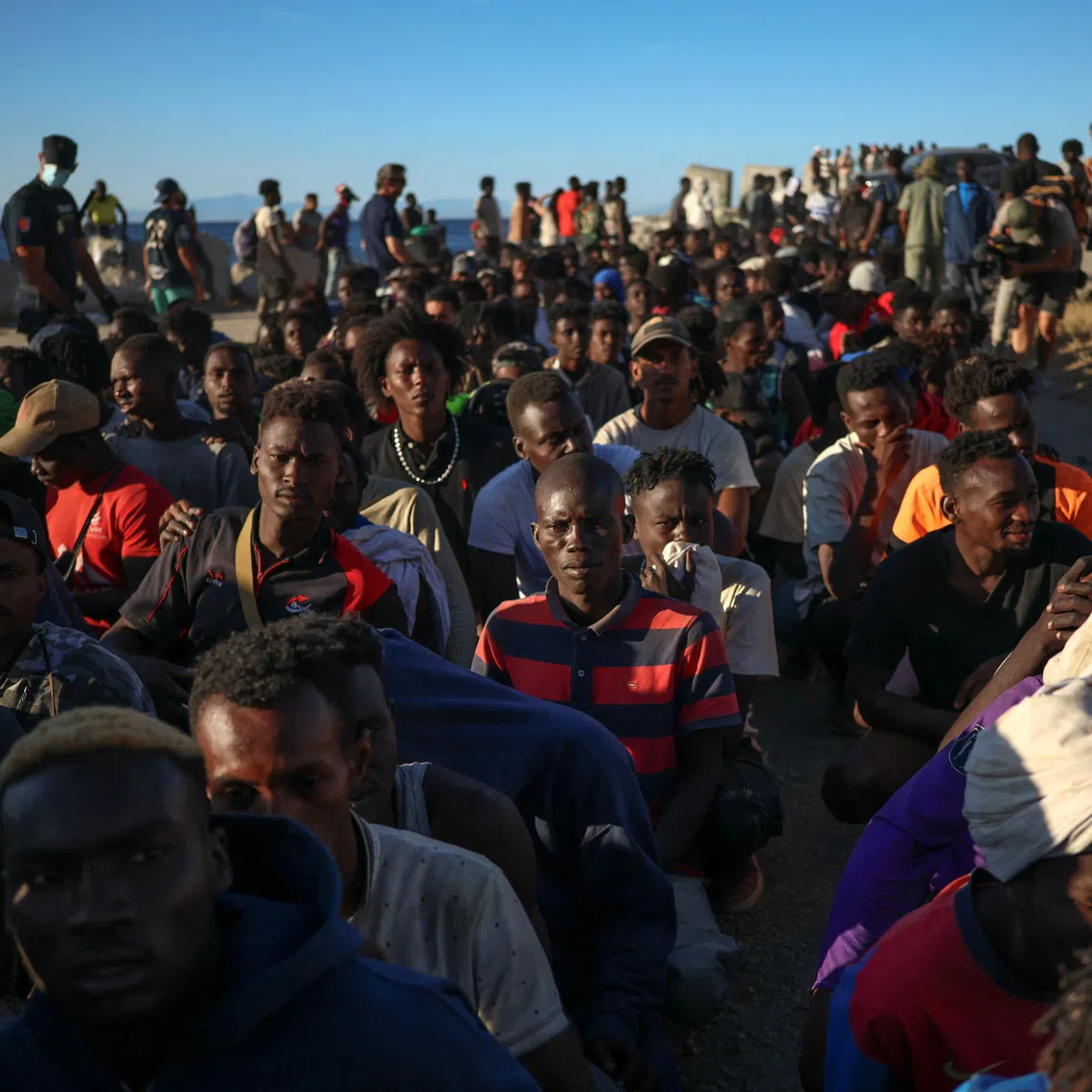 Migrants wait in line to receive food and beverage from the Red Cross, following mass crossings of migrants on foot and by sea from Morocco into Spanish territory, in Ceuta, Spain, August 3, 2026. REUTERS/Pedro Nunes