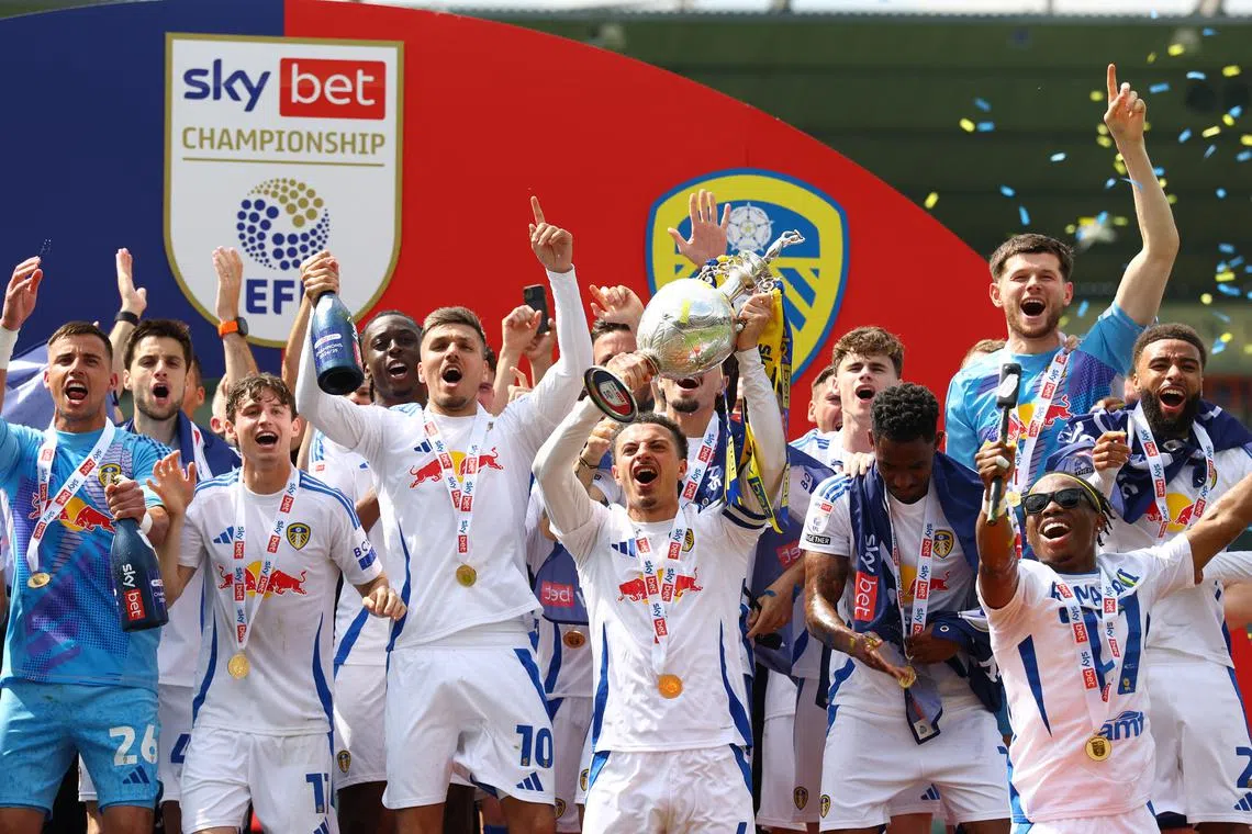 Soccer Football - Championship - Plymouth Argyle v Leeds United - Home Park, Plymouth, Britain - May 3, 2025 Leeds United's Ethan Ampadu lifts the trophy as he celebrates with his teammates after winning the Championship Action Images/Matthew Childs