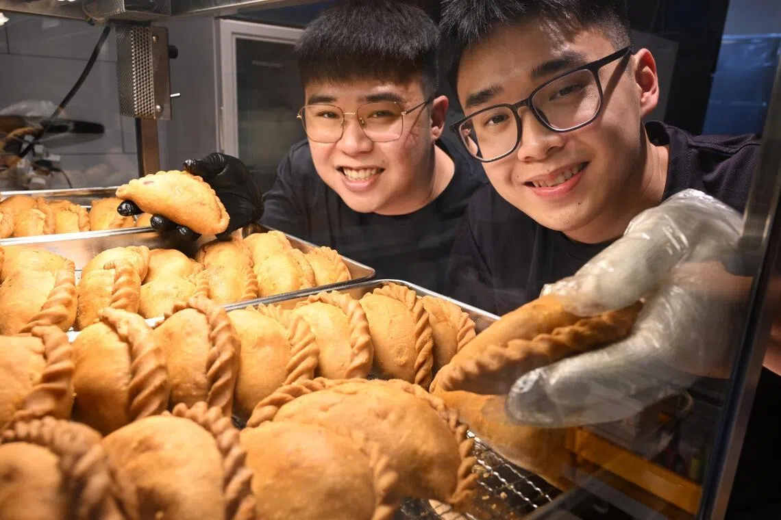 Mr Brandon Lim and his brother Yuan Ming with their curry puffs. 
