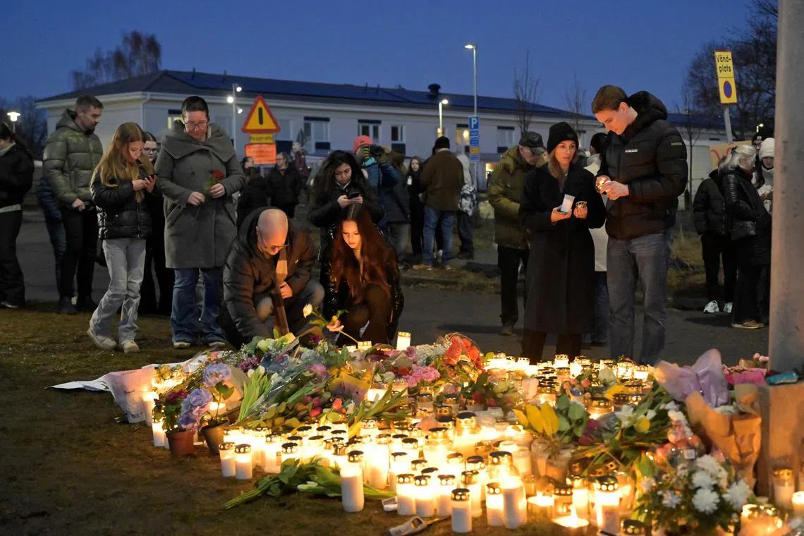 Mourners gather to place flowers and candles outside Risbergska School in Orebro the day after the school shooting in which over 10 people lost their lives, in Sweden Feburary 5, 2025. TT News Agency/Anders Wiklund via REUTERS
