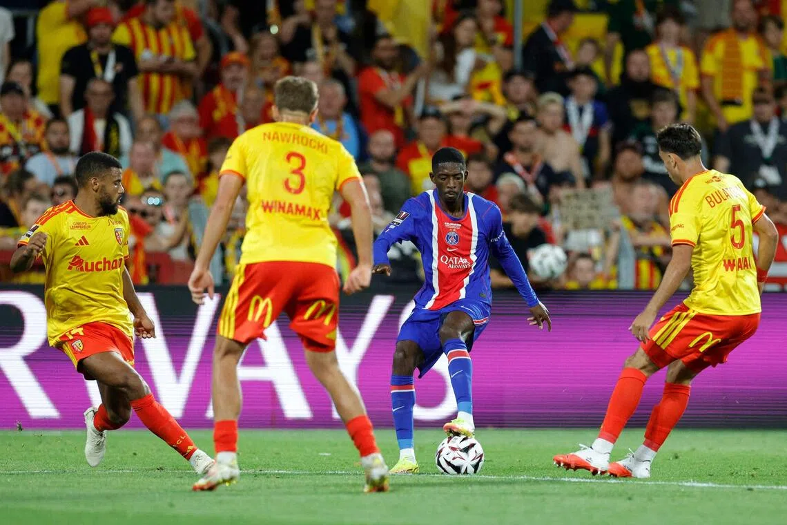 PSG’s reigning Ballon D’or winner Ousmane Dembele surrounded by three Lens players.