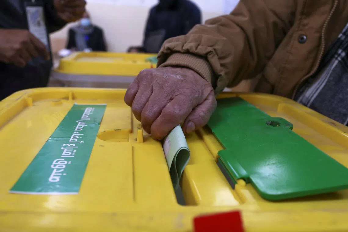 FILE PHOTO: A voter casts a ballot to vote in the municipal and local governorate councils elections in Amman, Jordan, March 22, 2022. REUTERS/Alaa Al Sukhni/File Photo