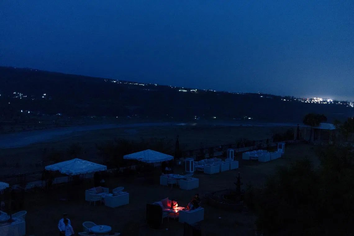 A family sits in an open restaurant just before a suspected Pakistani attack in Jammu, May 8, 2025. REUTERS/Adnan Abidi