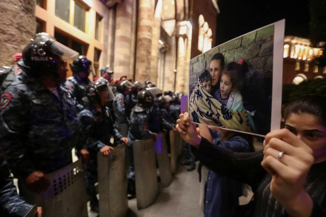 A protester shows a photograph near the government building during a rally to support ethnic Armenians in Nagorno-Karabakh following Azerbaijani armed forces' offensive operation executed in the region, in Yerevan, Armenia, September 20, 2023. REUTERS/Irakli Gedenidze/File Photo