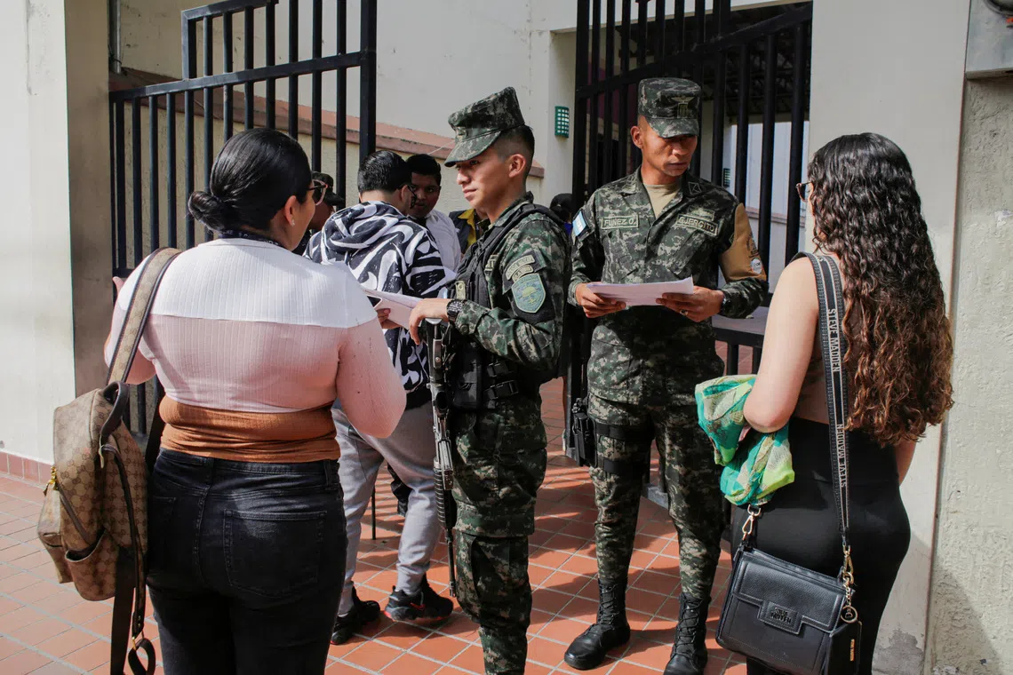 Members of the military screen employees entering the National Electoral Council (CNE) facility as the vote count in the November 30 presidential election resumes after being suspended for three days, in Tegucigalpa, Honduras December 8, 2025. REUTERS/Leonel Estrada