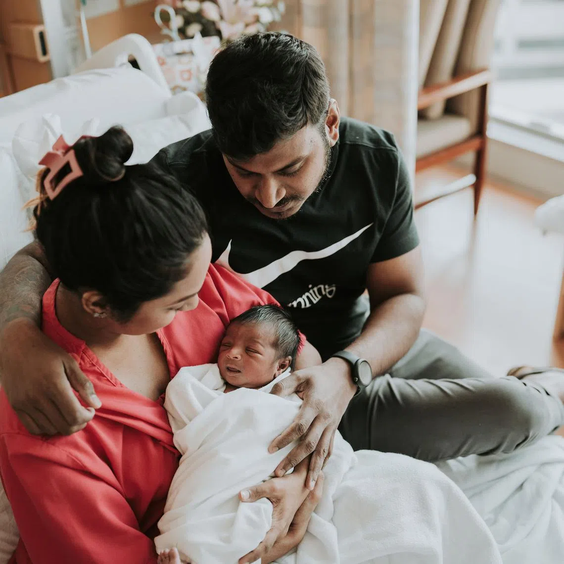 Mdm Arathi Manogaran and her husband Mr Vinodan embracing their then newborn baby boy, Kieran, as first-time parents.