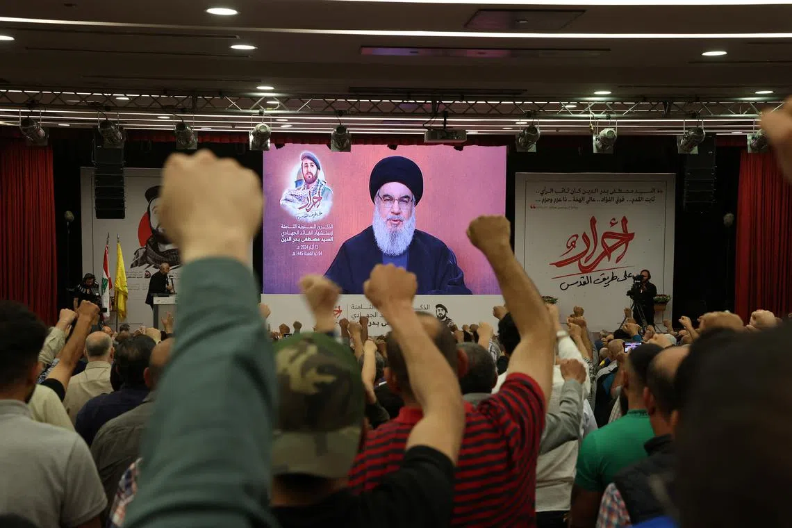 FILE PHOTO: Supporters of Lebanon's Hezbollah leader Sayyed Hassan Nasrallah gesture as Narallah gives a televised address during a rally in Beirut's southern suburbs, Lebanon May 13, 2024. REUTERS/Mohamed Azakir/File Photo