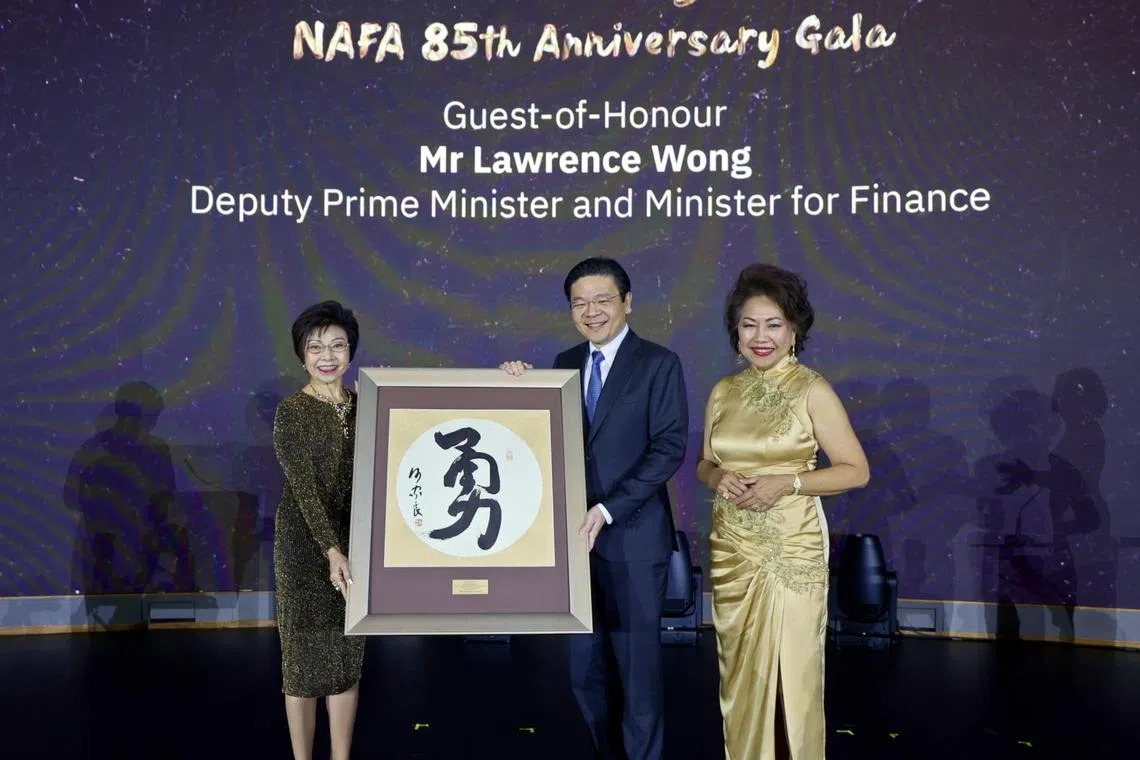 DPM Lawrence Wong receiving a memento from Nanyang Academy of Fine Arts chairman Low Sin Leng (left) and Dr Lucy Ooi during the institution's 85th anniversary.