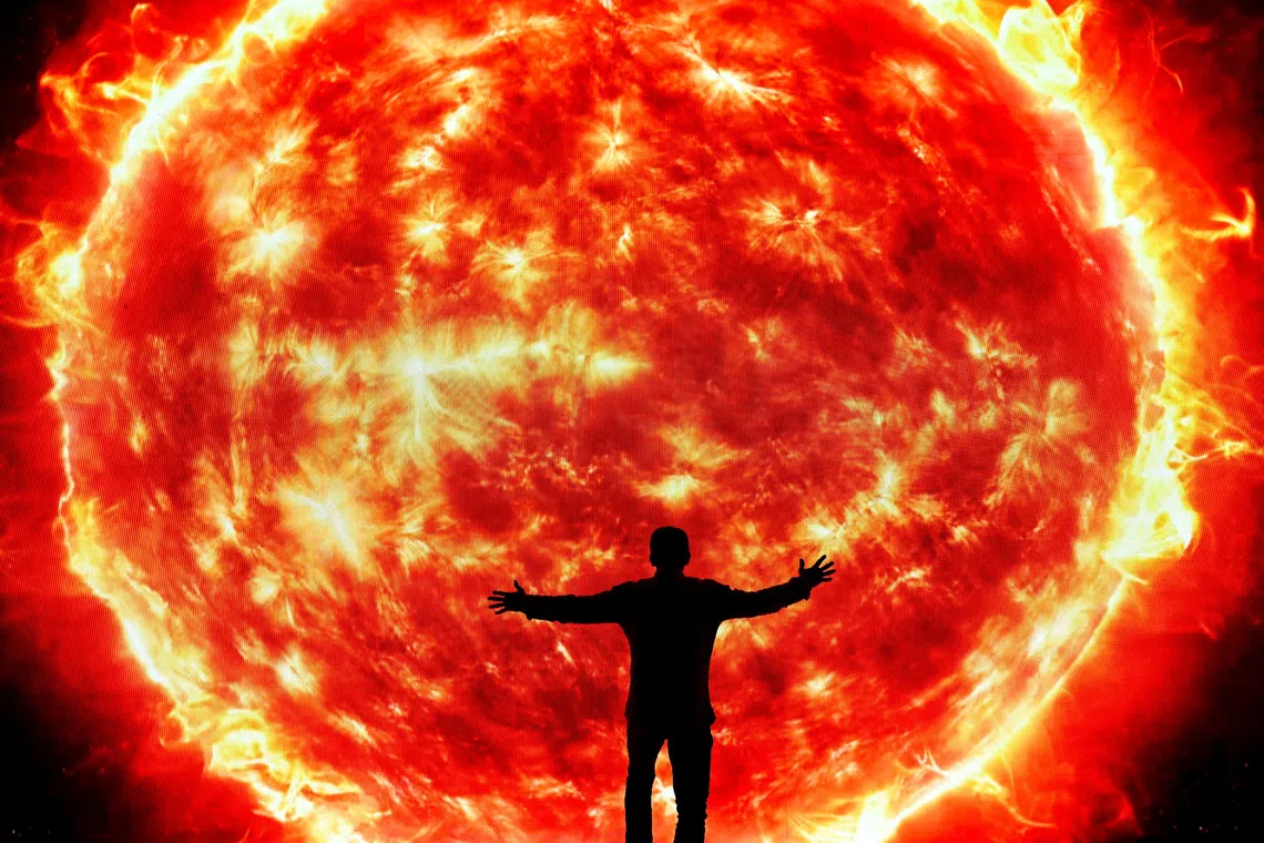 A man extends his arms in front of a screen showing a picture of the sun in the La Carlota convention center during the inauguration of a space-themed children's exhibition on the solar system, in Caracas, Venezuela December 5, 2025. REUTERS/Gaby Oraa     TPX IMAGES OF THE DAY