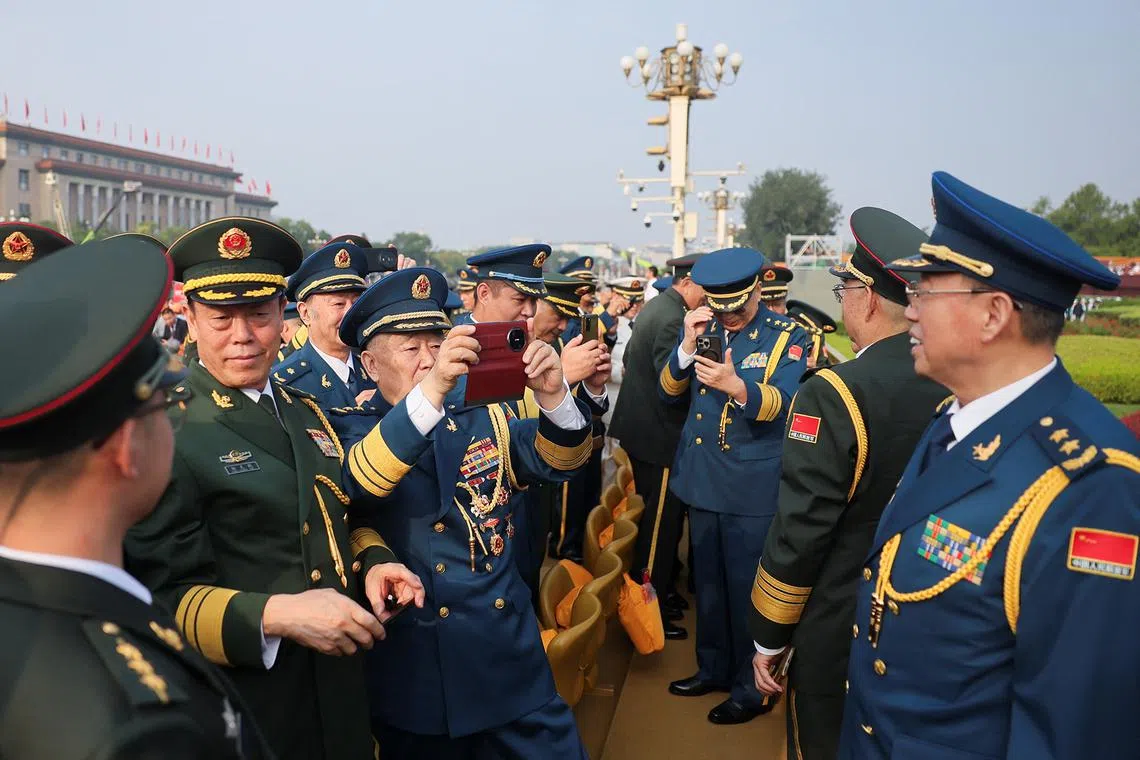 Military personnel using their mobile phones on the day of a military parade marking the 80th anniversary of victory over Japan and the end of World War II, in Beijing’s Tiananmen Square, China, on Sept 3, 2025. 
