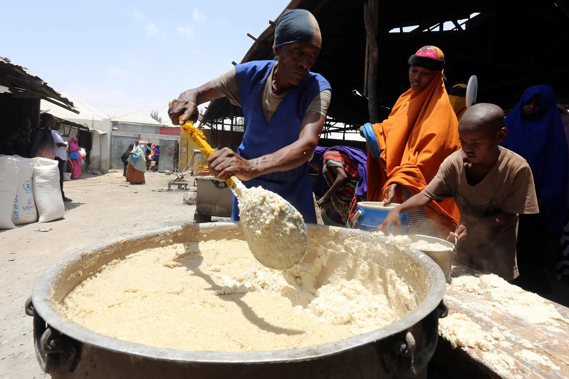 A volunteer serves internally displaced Somali people with cooked food from the United Nations World Food Programme (WFP) feeding program at the Sorrdo camp in Hodan district of Somalia's capital Mogadishu, March 11, 2017. REUTERS/Feisal Omar