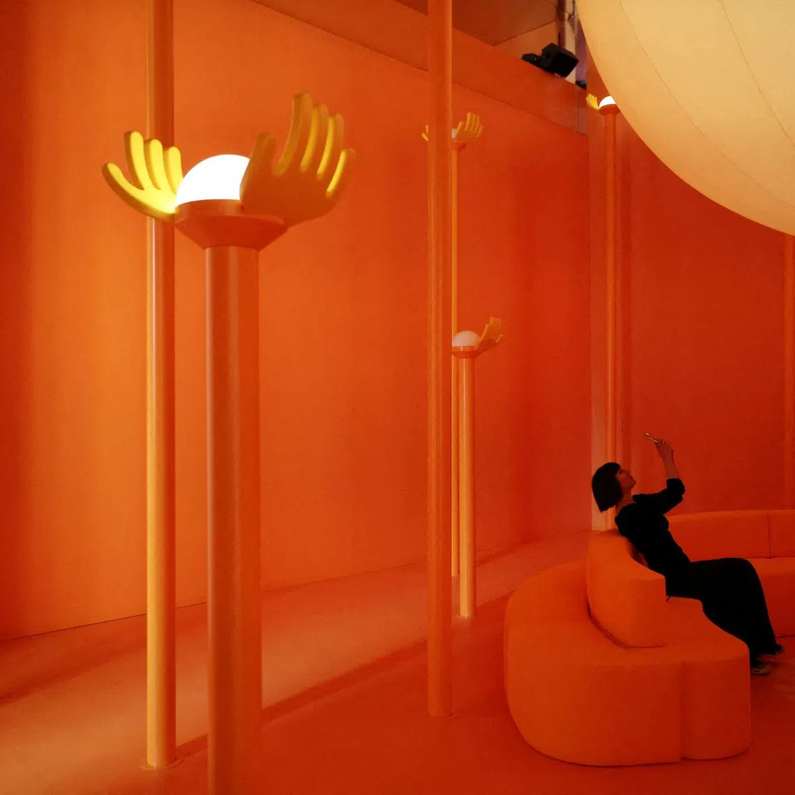 A woman sitting on a sofa at the Veuve Clicquot "Chasing the Sun" installation, in collaboration with British-Nigerian artist and designer Yinka Ilori, as part of the Milan Design Week Fuorisalone exhibition, in Milan, Italy, on April 20, 2026.