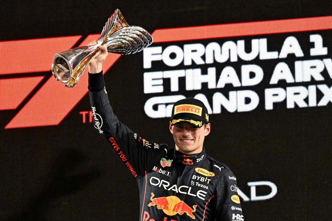 Red Bull's Dutch driver Max Verstappen raising the winner's trophy on the podium after the Abu Dhabi Formula One Grand Prix at the Yas Marina Circuit in the Emirati city of Abu Dhabi on Sunday.