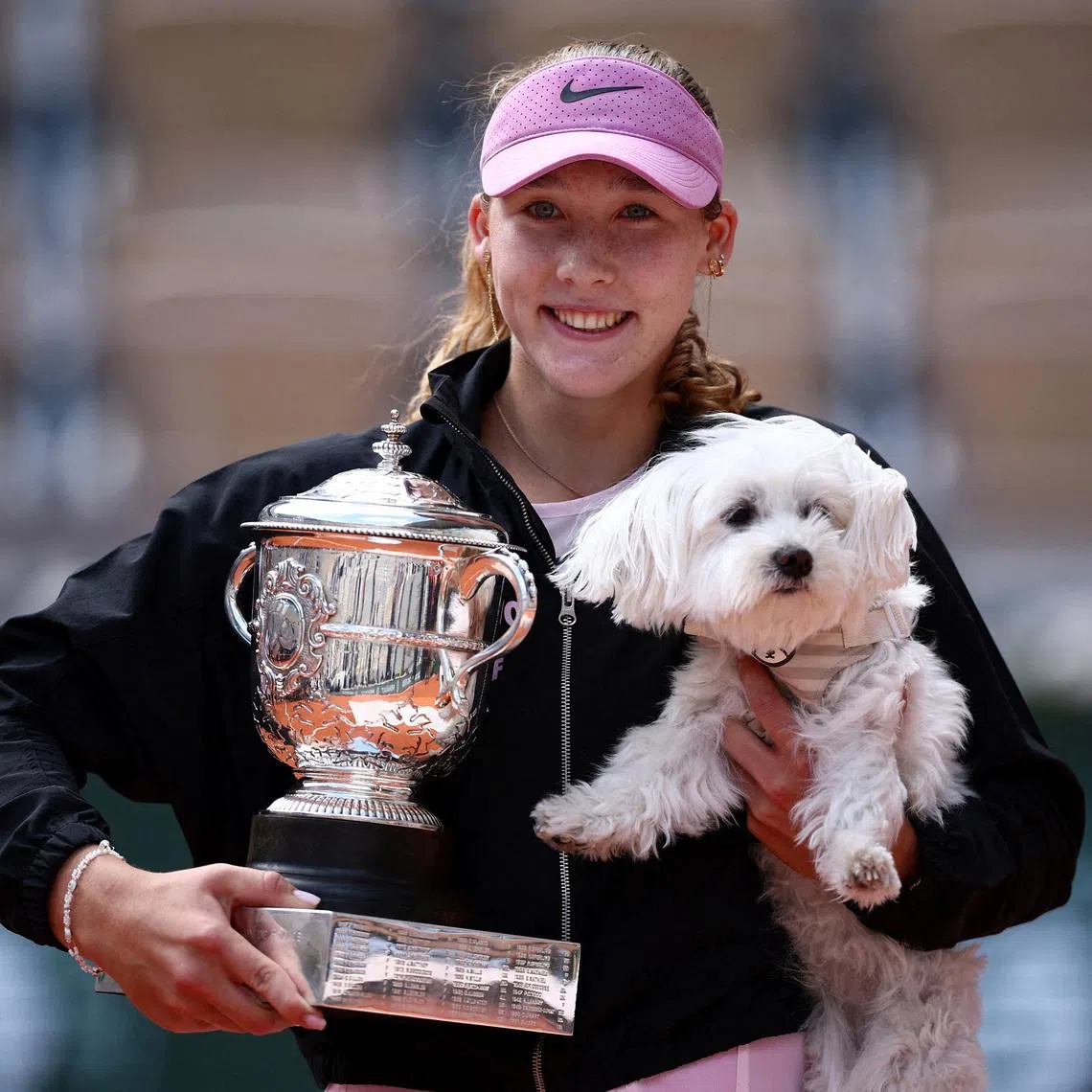 Tennis - French Open - Roland Garros, Paris, France - June 6, 2026 Russia's Mirra Andreeva celebrates with the trophy and a dog after winning her final match against Poland's Maja Chwalinska REUTERS/Guglielmo Mangiapane
