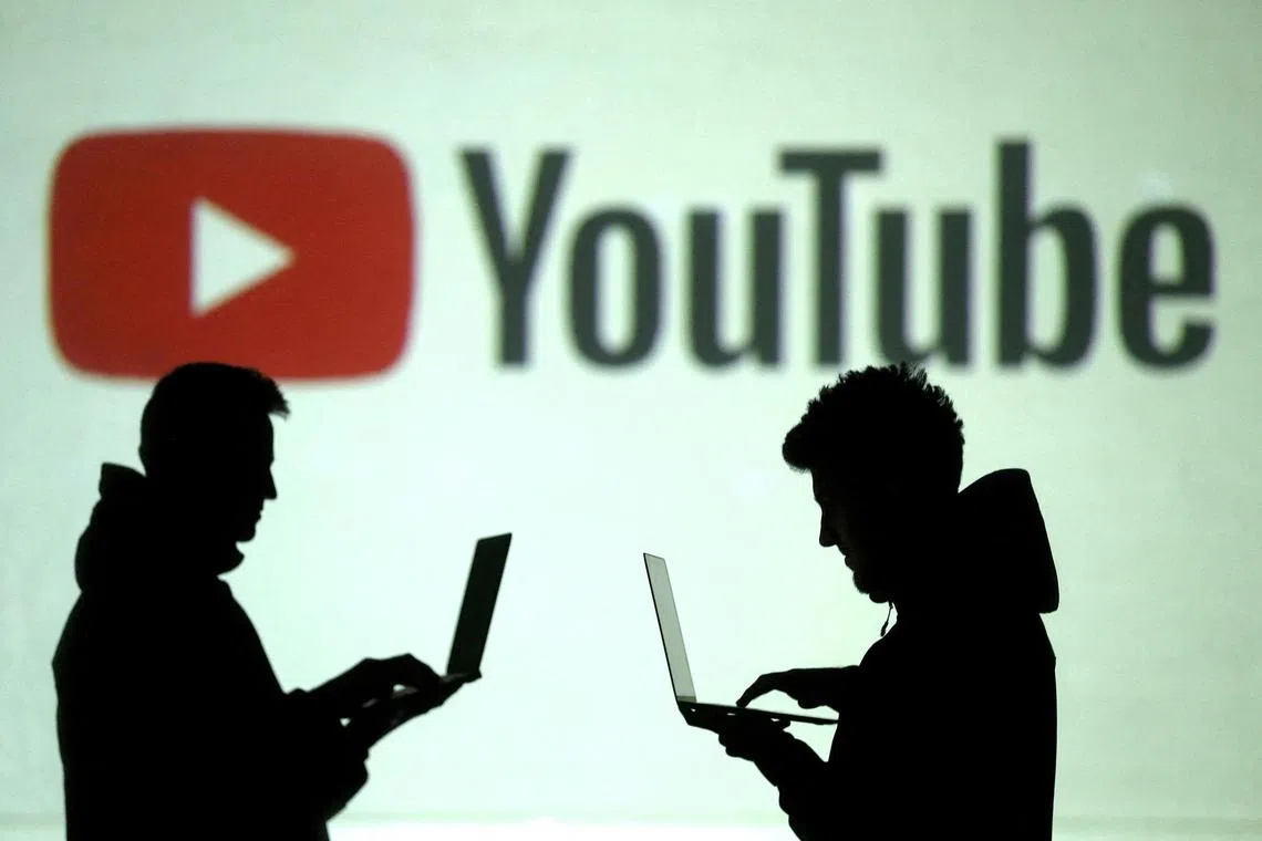 FILE PHOTO: Silhouettes of mobile device users are seen next to a screen projection of Youtube logo in this picture illustration taken March 28, 2018.  REUTERS/Dado Ruvic/Illustration/File Photo