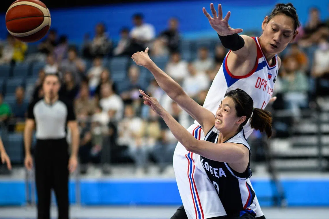 North Korea's Pak Ji Na (top R) trying to block South Korea's Lee Kyung-eun from passing the ball in the women's bronze medal basketball game between North Korea and South Korea during the Hangzhou 2022 Asian Games in Hangzhou, China on Oct 5.