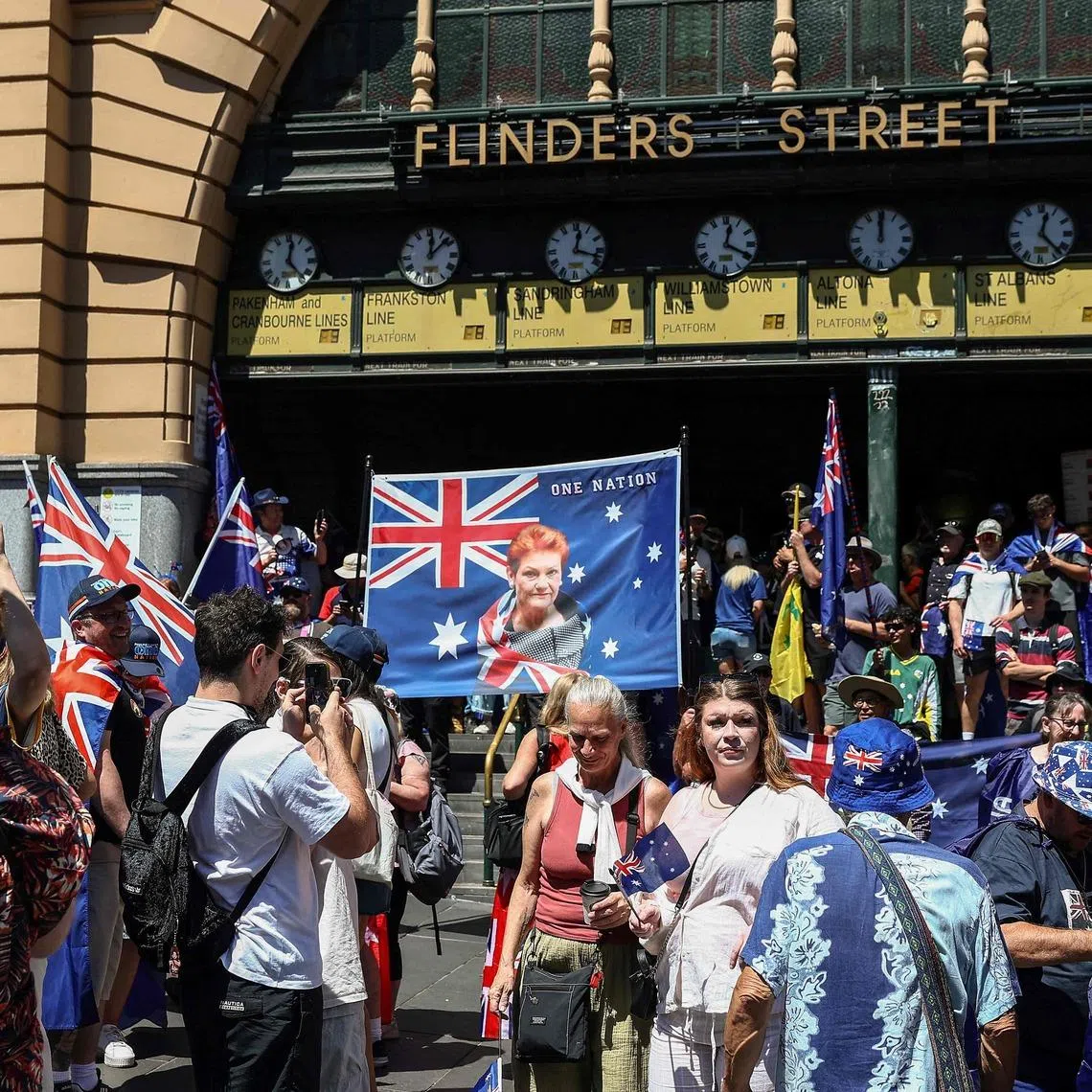 A demonstrator displays a banner showing One Nation Senator Pauline Hanson (C) during an anti-government protest rally on Australia Day in Melbourne on January 26, 2026. (Photo by Izhar KHAN / AFP)