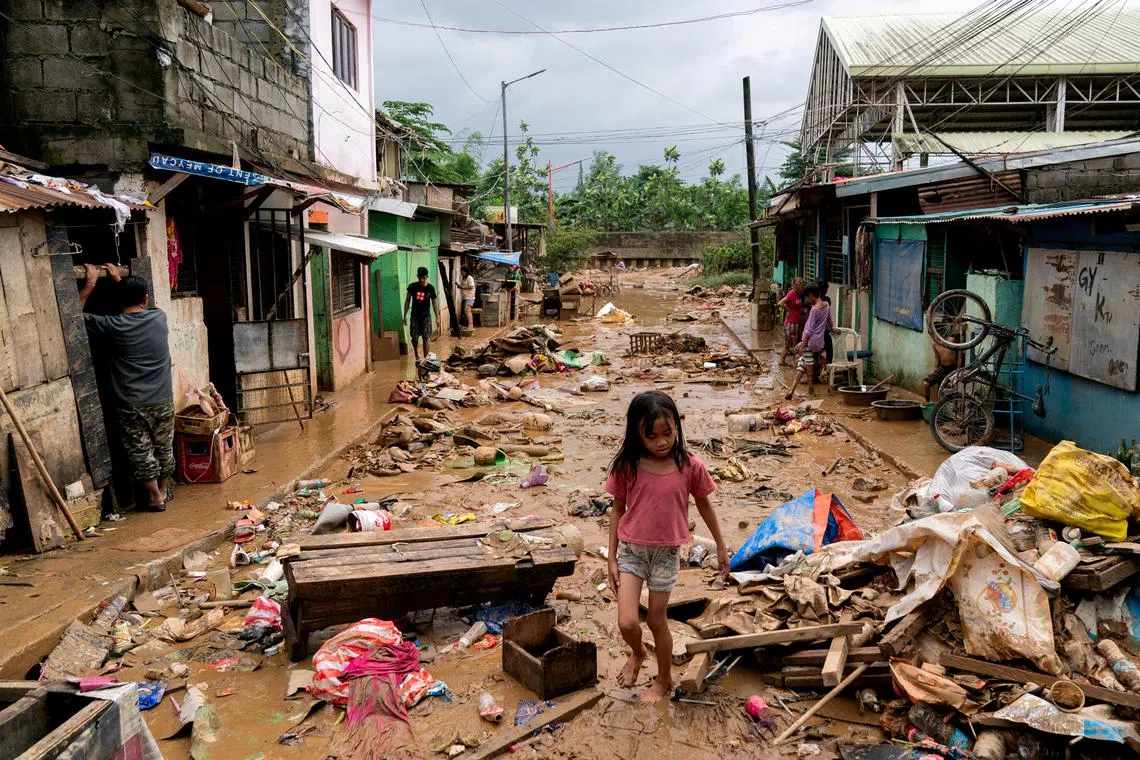 FILE PHOTO: A girl walks past the debris and mud following the floods brought by Typhoon Gaemi, in Marikina City, Metro Manila, Philippines, July 25, 2024. REUTERS/Lisa Marie David/File Photo