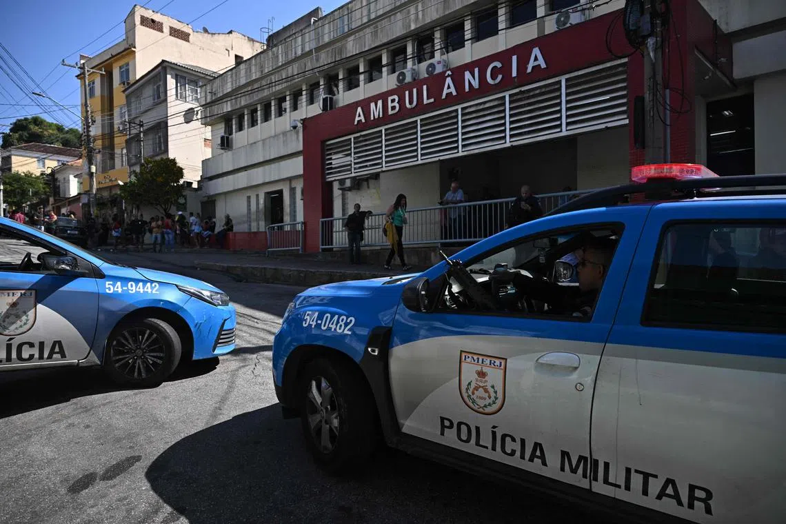Military police vehicles are seen outside a hospital in Rio de Janeiro to which the dead and injured were taken after the raids.