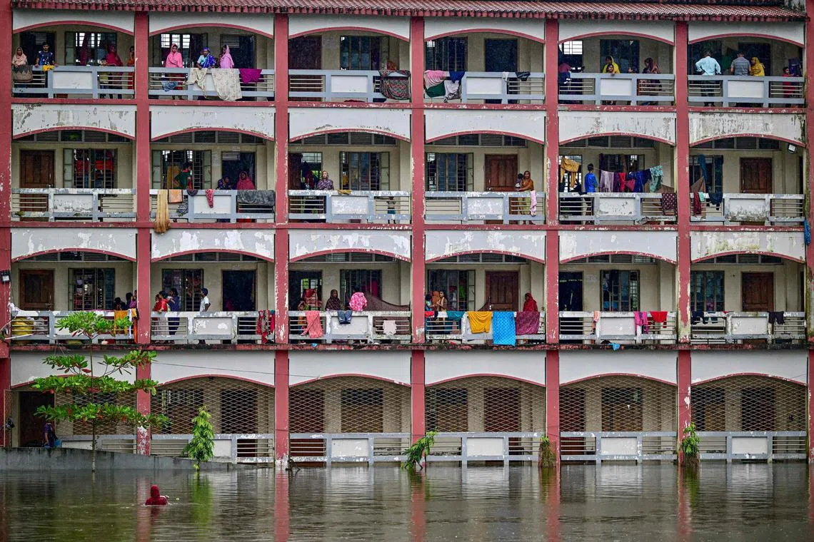 Flood-affected people taking shelter inside a school building in Daganbhuiyan, Feni, on August 25, 2024. River waters in low-lying Bangladesh are receding after days of deadly floods, but 300,000 people remain in emergency shelters requiring aid, disaster officials said on August 25. 
