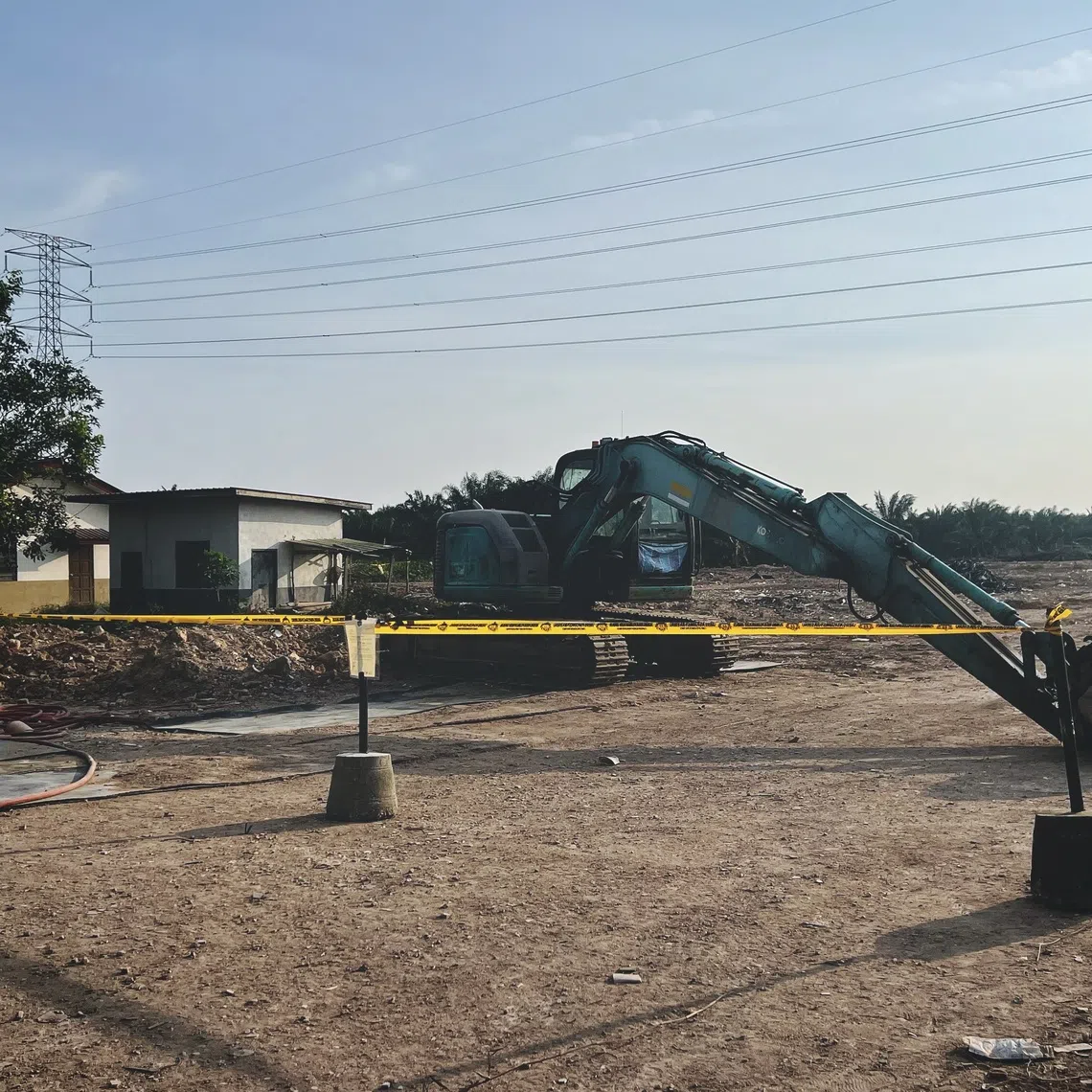 A cordoned-off site, believed to be used for the illegal dumping of construction waste from Singapore, in a village in Pontian, Johor, on Aug 12.