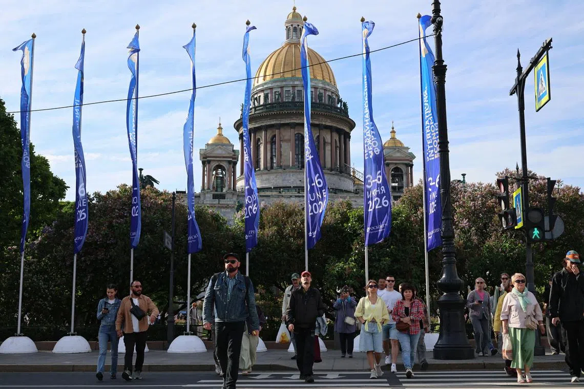 People cross the street near flags with the logo of the St. Petersburg International Economic Forum (SPIEF) flying in front of the St. Isaac's Cathedral on the eve of the forum's opening in Saint Petersburg, Russia June 2, 2026. REUTERS/Anastasia Barashkova